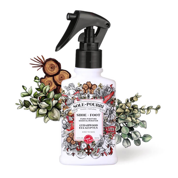 A white spray bottle with a charming floral design, labeled Sole-Pourri, is nestled amid fresh eucalyptus and earthy wooden accents, exuding natural elegance.