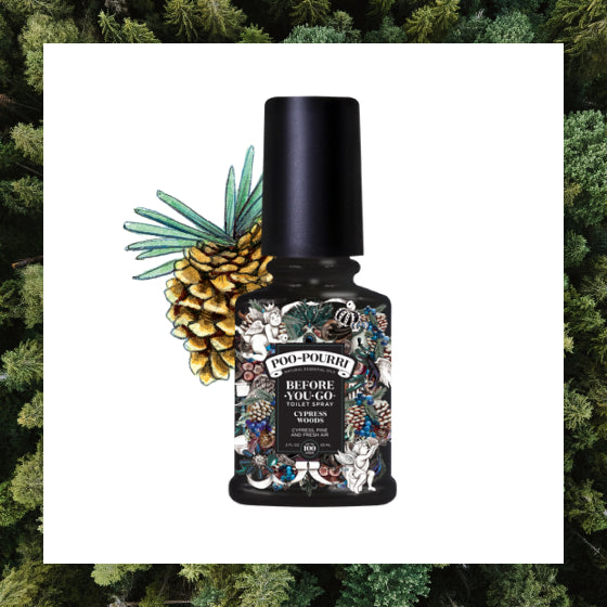 A sleek black bottle of Poo-Pourri toilet spray, adorned with an aromatic pine design, blends naturally into a lush pine tree forest backdrop.