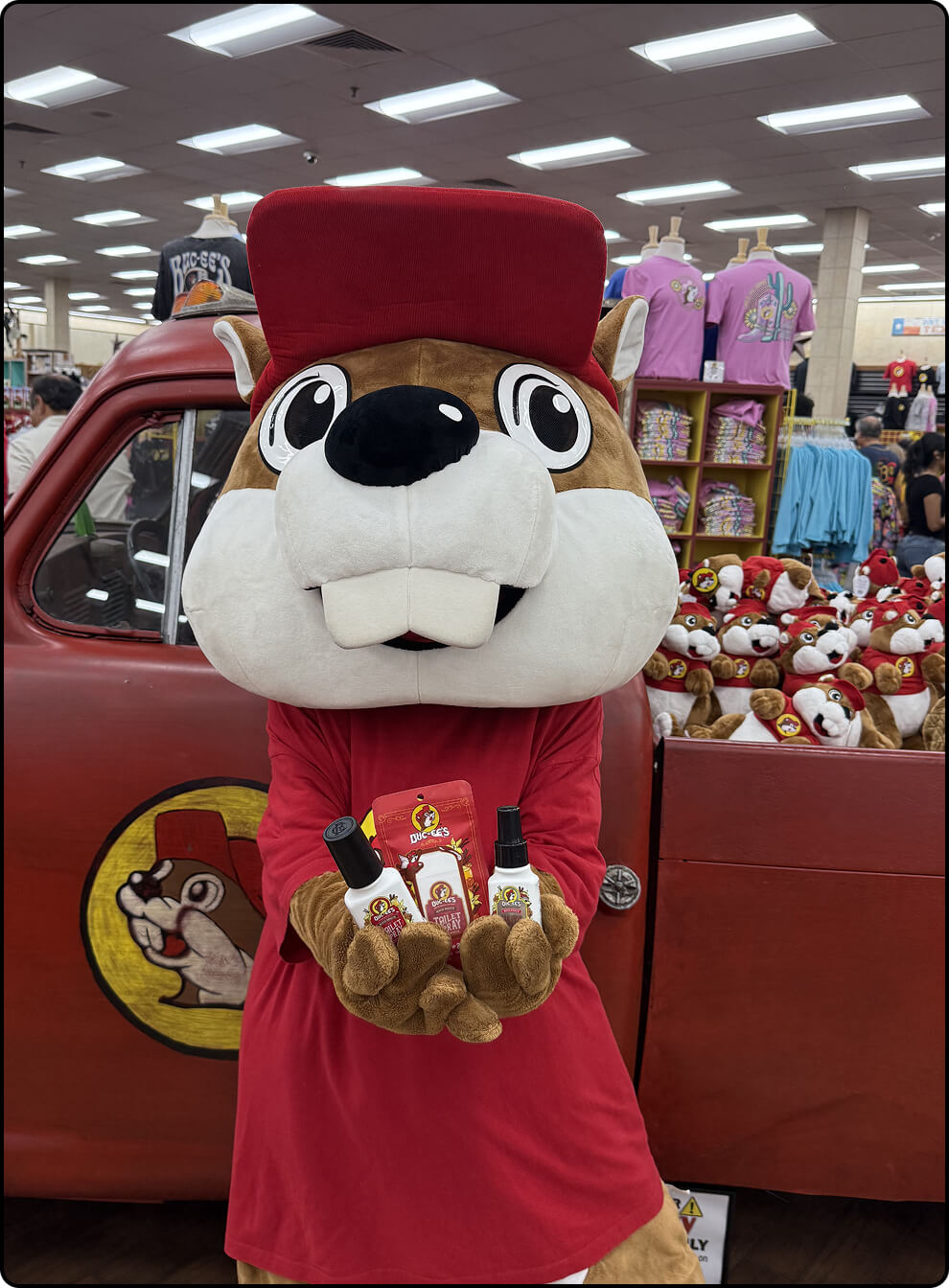 Bucky the beaver holding exclusive Buc-ee's Poo~Pourri beaver nuggets scented toilets spray bottles