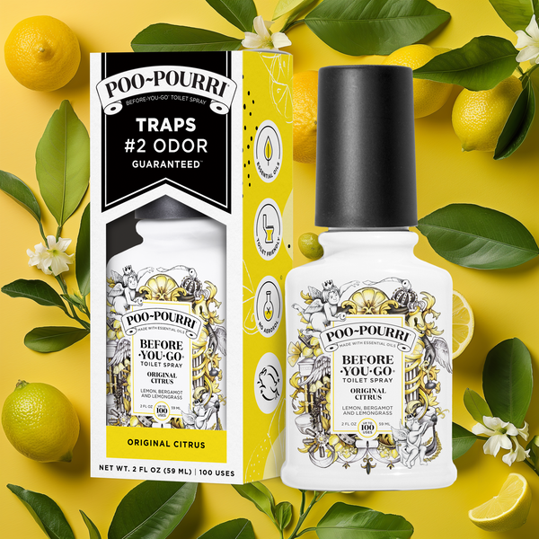 A ~Poo-Pourri “Before You Go” toilet spray in the Original Citrus scent is displayed alongside its packaging against a decorative yellow background, featuring lemons and leaves. The bottle and box have an intricate design with cherubs, toilet paper, and citrus elements, highlighting the ingredients. The packaging emphasizes the product’s ability to trap odors before they start, with key details such as “100 Uses,” “No Aerosols,” and “Essential Oils” visible.