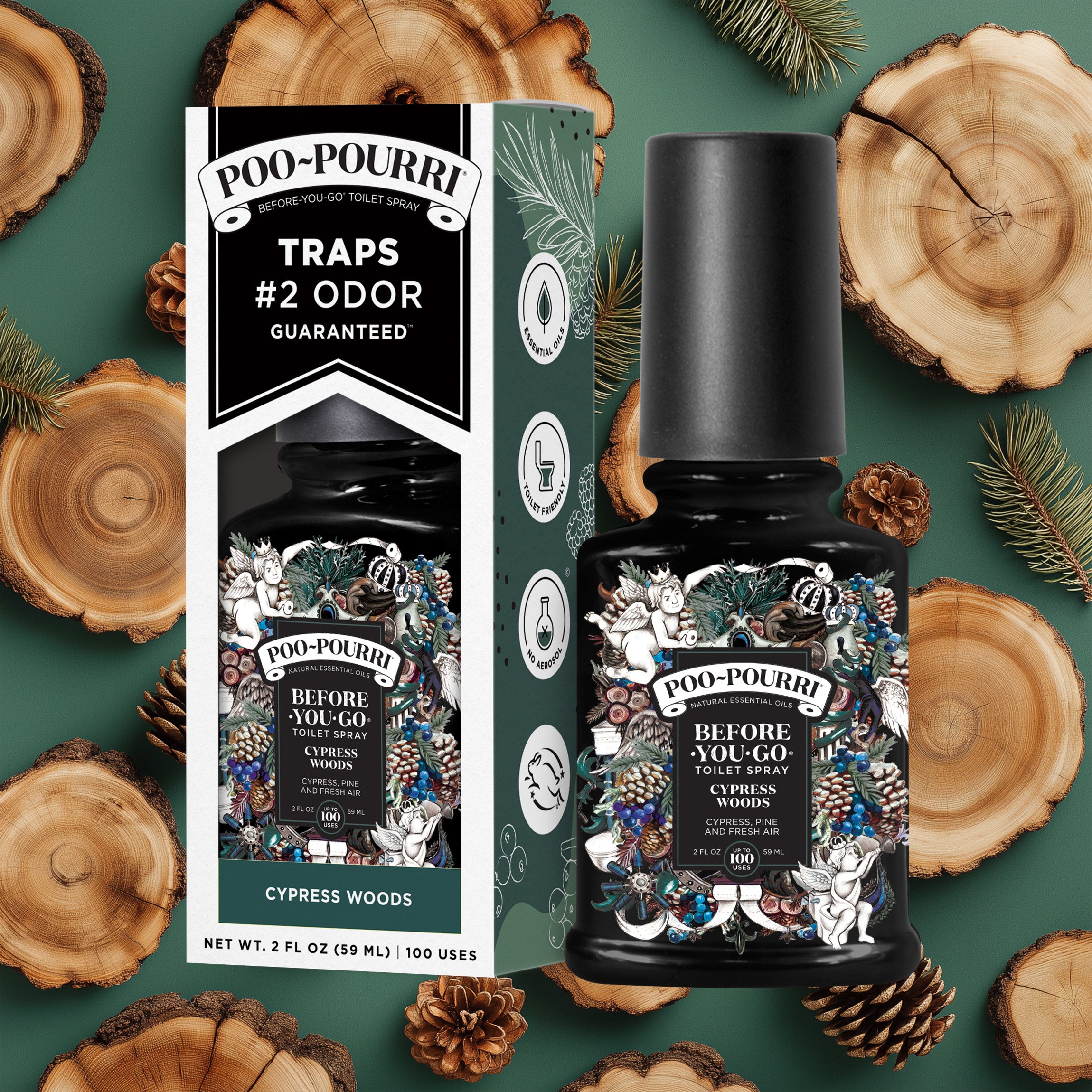A ~Poo-Pourri “Before You Go” toilet spray in the Cypress Woods scent is displayed alongside its packaging against a decorative dark green background, featuring wood and pine cones. The bottle and box have an intricate design with cherubs, toilet paper, and woody elements, highlighting the ingredients. The packaging emphasizes the product’s ability to trap odors before they start, with key details such as “100 Uses,” “No Aerosols,” and “Essential Oils” visible.