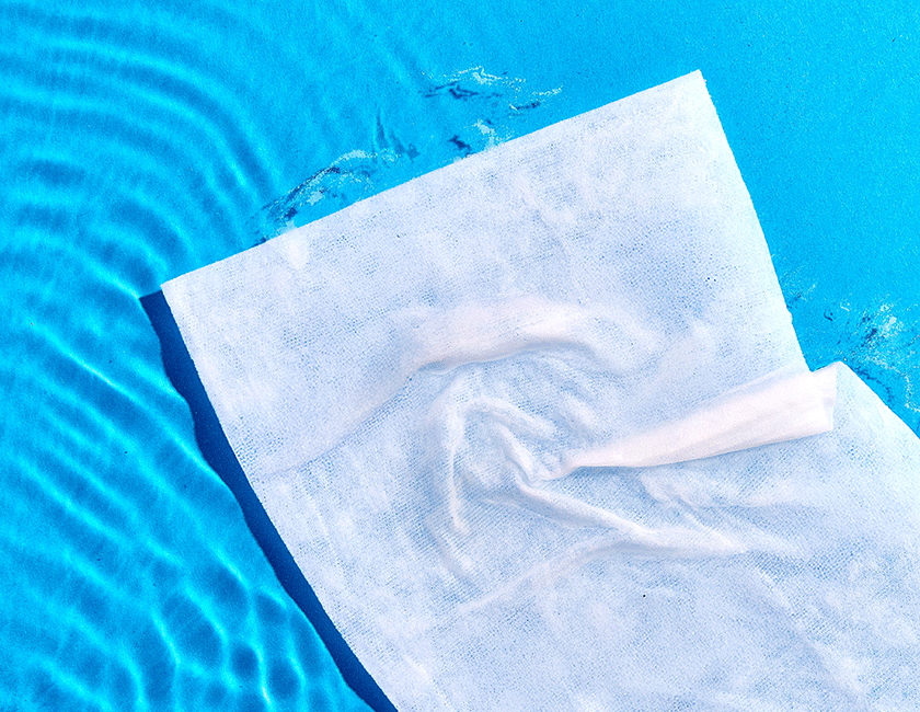 Short gif that shows a Poo~Pourri flushable wipe in water, breaking down, and fully dissolving.