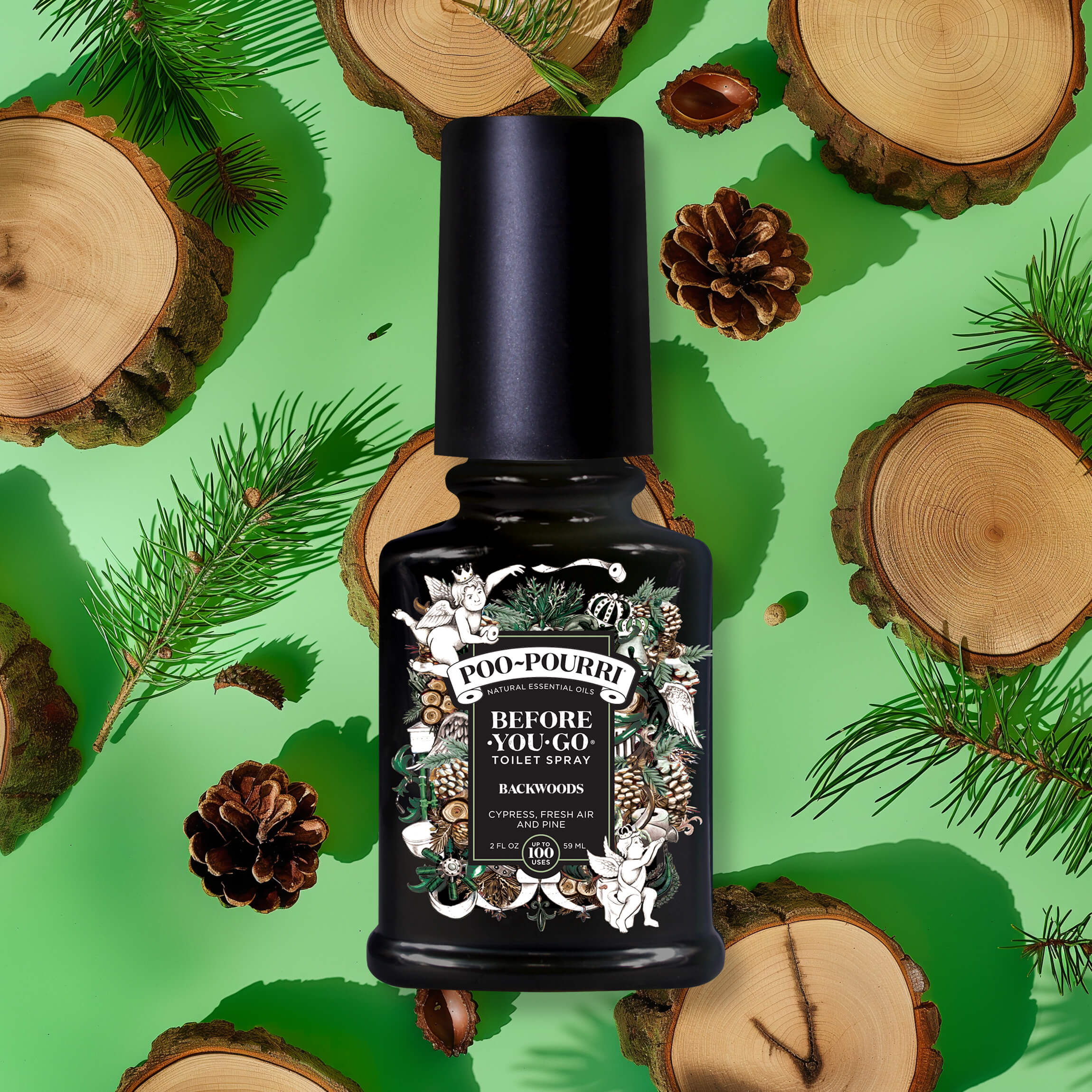 The Backwoods - Poo~Pourri Toilet Spray from ~Pourri is displayed on a green backdrop with pine branches, cones, and wood slices, highlighting its fresh formula with essential oils that traps odors.